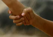 A hand grabbing another person's hand - helping.