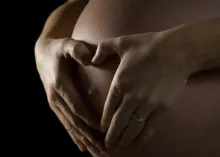 Woman holding pregnant belly.