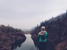 A young woman looking over a lake.