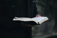 A man holding an open Bible.