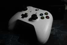 a white video game controller with black buttons
