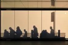 People walking creating shadows on building walls.