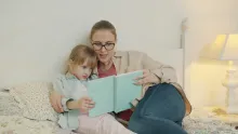a woman reading a book to a child