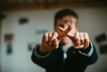 Fingers crossed pushing someone away