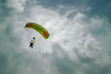 a man with a parachute in a sky filled with clouds