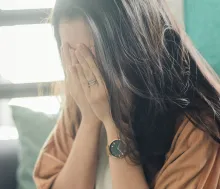 a woman sitting with her face in her hands