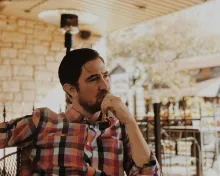 A man in deep thought while sitting outside.