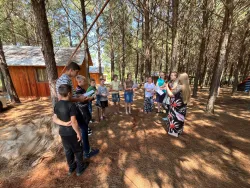 a group of children standing in a semicircle outside and singing