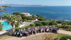 a large group of people standing outside the Mediterranean in the background