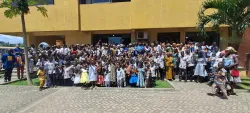 a large group of people gathered in front of a yellow building