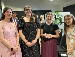 four young ladies standing together and smiling