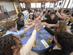 Campers at a round table clinking glasses