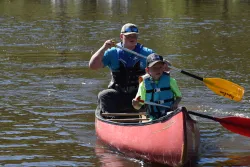 a man and a boy in a canoe