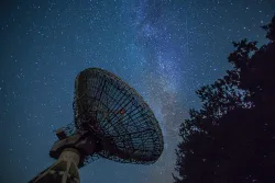 a telescope angled up at the starry night sky