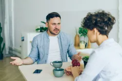 Two people sitting at a table in an intense conversation