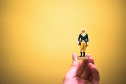 A person holding a small figurine in their hand.