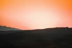 A sunset over a hill.