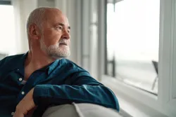 An man looking out a window.