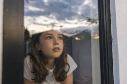 A little girl looking out the window.