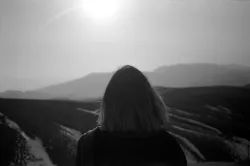 A woman looking at over a vista - a challenge to travel through.