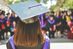 a woman's head wearing a graduation cap as she faces a crowd