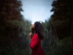 a woman praying outdoors