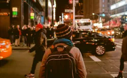 woman crossing a city road at nighttime