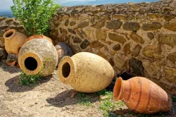 a stone wall and a line of ancient clay jars