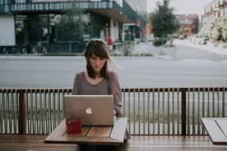 A young woman looking a laptop screen.