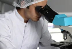 A person looking through a microscope.