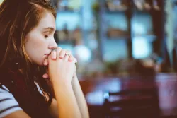 A young woman praying.