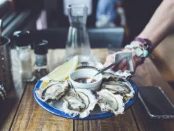 Raw oysters being served on a platter in a restaurant.