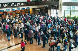 Airport travelers standing in line to go through immigration customs.