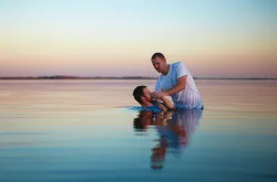 A man putting another man under water.