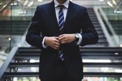 Photo of a man buttoning a tailored suit.