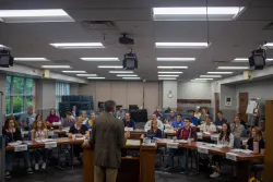 Dr. Frank Dunkle stands at the lectern facing a group of students.