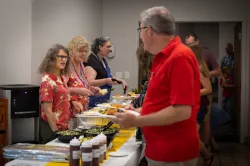 home office employees on both sides of a food serving line