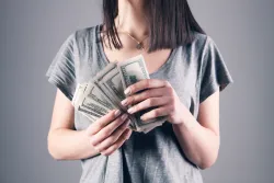 a woman holding one-hundred dollar notes