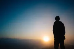 A person looking at a sunset.