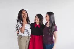 a group of three women smiling and laughing