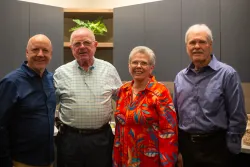 four people standing indoors