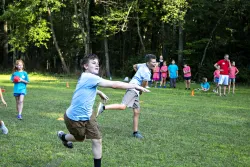a group of children running and playing a game in a field
