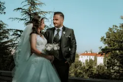 a bride and a groom looking at each other while standing outside