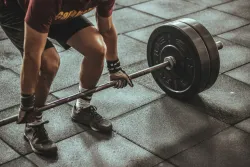 a man squatting to pick up a heavy weight