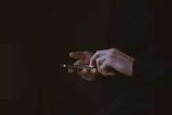 A person using a smartphone in the dark.