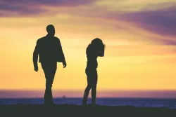 silhouette of man and woman against a yellow sky