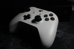 a white video game controller with black buttons