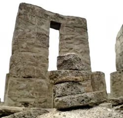 a stack of stones in front of an ancient ruined wall