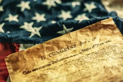 The Declaration of Independence on top of a US flag.