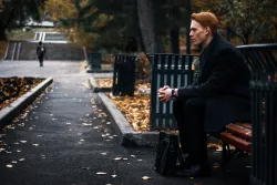A man sitting on a park bench - thinking.